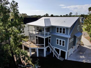 Two-story house with a metal roof, deck, and screened porch at 1999 N Creek Dr, Mount Pleasant, SC 29466