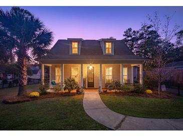 Charming house with a welcoming front porch and landscaped yard at 318 Simmons Ave, Summerville, SC 29483