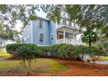 Two-story light blue house with white trim and a wrap-around porch at 5250 Timber Race Crse, Hollywood, SC 29449