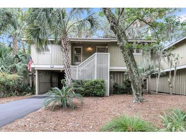 Exterior view of a charming two-story house with lush landscaping at 1111 Summerwind Lane, Seabrook Island, SC 29455