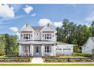 Two story farmhouse style home with landscaping at 1180 Reserve Ln, Awendaw, SC 29429
