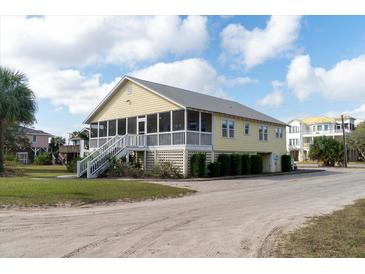 Yellow two-story house with screened porch and stairs leading to entrance at 2302 Palmetto Blvd, Edisto Beach, SC 29438