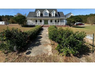 Two story home with wrap around porch and landscaped yard at 204 Charles St, Saint George, SC 29477