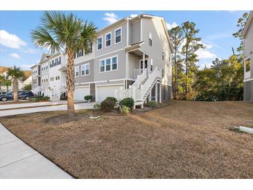 Three story townhome with attached garage and front yard at 139 Winding River Dr, Johns Island, SC 29455