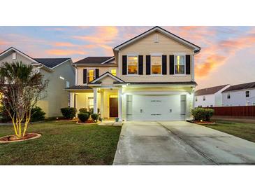 Two-story house with a beige exterior, a white garage door, and a well-manicured lawn at 108 Glenspring Dr, Summerville, SC 29486