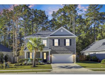 Two-story home with gray brick and white trim, featuring a front porch and attached garage at 700 Kilarney Rd, Summerville, SC 29483