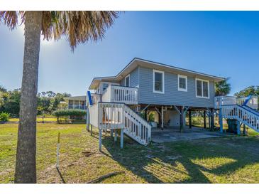 Elevated beach house with a wrap-around porch and large backyard at 3131 Palmetto Blvd, Edisto Island, SC 29438
