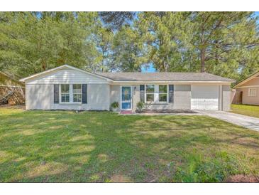 Newly painted grey brick ranch home with a blue door, and a well-manicured lawn at 3264 Stonehaven Dr, North Charleston, SC 29420