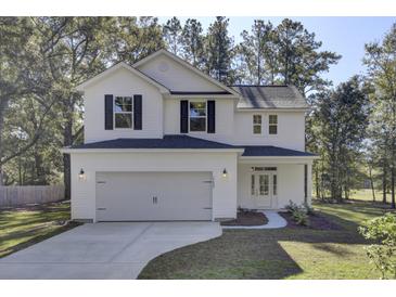 Two-story white house with black shutters, gray roof, and a two-car garage at 5629 Ellington School Rd, Ravenel, SC 29470