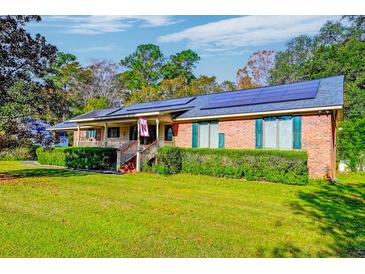 Brick ranch home with solar panels, large yard, and covered porch at 185 Old Fort Dr, Ladson, SC 29456