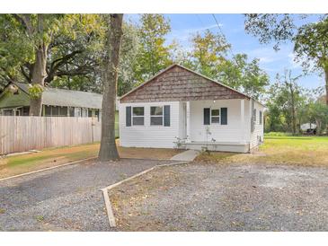 Charming white cottage with wood accents and a gravel driveway at 1979 Macon Ave, North Charleston, SC 29405
