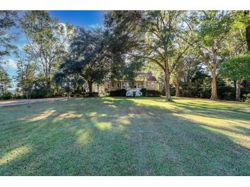Beautiful home nestled on a spacious lot with mature trees and lush lawn at 4415 Lord Proprietors Rd, Hollywood, SC 29449