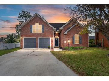 Brick house with 2-car garage, landscaping, and a paved driveway at 1412 White Ibis Ct, Hanahan, SC 29410