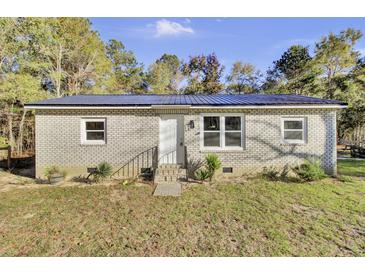 Brick ranch home with a metal roof and fenced yard at 1243 Pineville Cir, Pineville, SC 29468