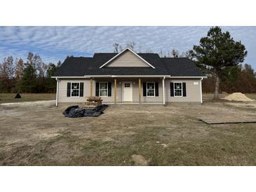 Newly constructed home with gray siding, black shutters, and a covered porch at 153 Dandelion Ct, Round O, SC 29474