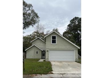 Two-story house with a large white garage door and light green siding at 114 Lewisfield Dr, North Charleston, SC 29418