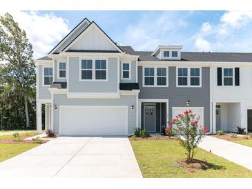Two-story townhome with gray siding, white garage doors, and landscaping at 569 Trotters Ln # 222, Moncks Corner, SC 29461