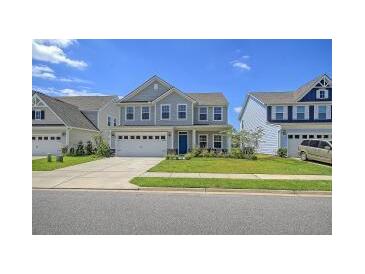 Two-story home with gray siding, two-car garage, and landscaped lawn at 113 Corvus St, Summerville, SC 29483