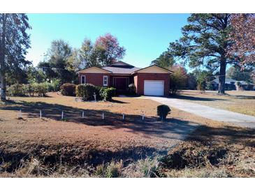 Brick ranch house with attached garage and mature landscaping at 153 Davis Ter, Saint George, SC 29477