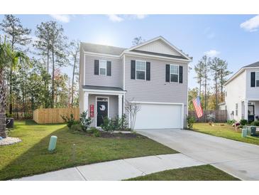 Two-story house with gray siding, a white garage door, and a well-maintained lawn at 671 Silver Spruce St, Summerville, SC 29486