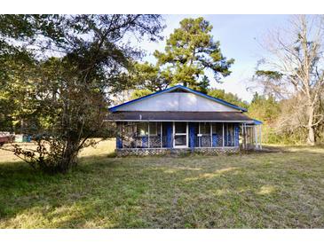 Ranch style home with blue accents and screened porch, nestled in a wooded lot at 8146 N Highway 17, McClellanville, SC 29458
