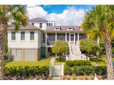 Charming two-story home with a metal roof, screened porch, and landscaped yard at 2220 Ion Ave, Sullivans Island, SC 29482