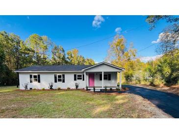Newly renovated house featuring a pink door and landscaped yard at 211 Water Wheel Rd, Ridgeville, SC 29472