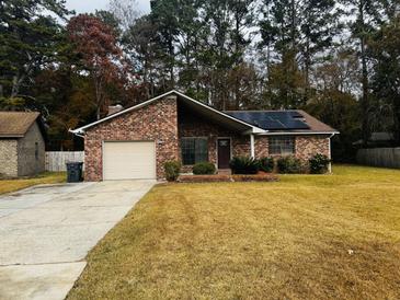 Brick ranch home with solar panels, attached garage, and a landscaped yard at 107 Pinewood St, Ladson, SC 29456