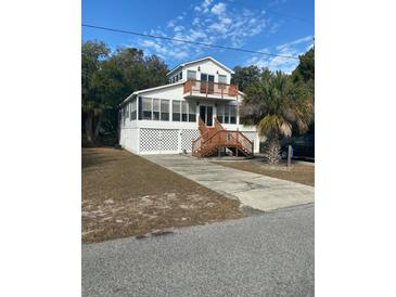Two-story beach home with wrap-around porch and spacious yard at 2305 Myrtle St, Edisto Beach, SC 29438