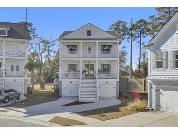 Two-story home with white siding, double garage, and large front porch at 149 Low Tide Ct, Charleston, SC 29492