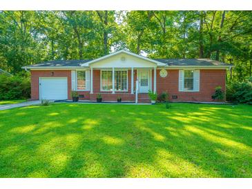 Brick ranch house with white trim, lush lawn, and mature trees at 314 Heber Rd, Summerville, SC 29485