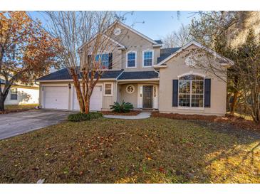 Two-story stucco home with a two-car garage and landscaped lawn at 7011 Windmill Creek Rd, Charleston, SC 29414
