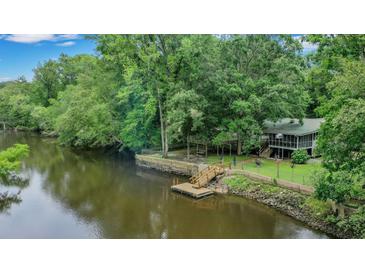 Charming riverside home with private dock and lush landscaping at 93 Deepwater Ave, Round O, SC 29474