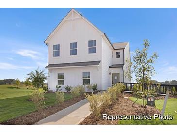 Charming white two-story home with a welcoming front porch and landscaped yard at 219 Night Heron St # 597P, Summerville, SC 29486