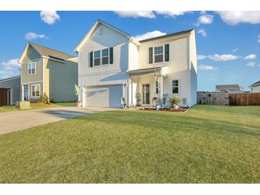 Two-story white house with a green door, landscaping, and a two-car garage at 432 Eva St, Moncks Corner, SC 29461