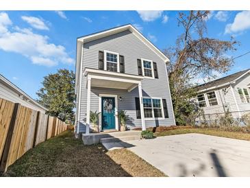 Charming two-story home with a teal front door, fenced yard, and driveway at 2042 Delaware Ave, North Charleston, SC 29405