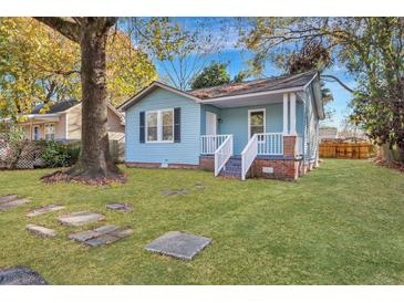 Charming blue cottage with white trim, front porch, and large yard at 2675 Houston St, North Charleston, SC 29405