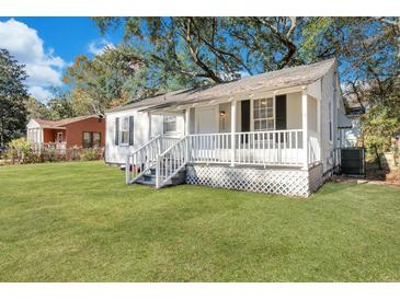 Charming white home with covered front porch and lush green lawn at 2754 Houston St, North Charleston, SC 29405