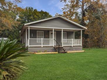 Charming gray cottage with a covered front porch and landscaped yard at 6713 Augusta Hwy, Smoaks, SC 29481