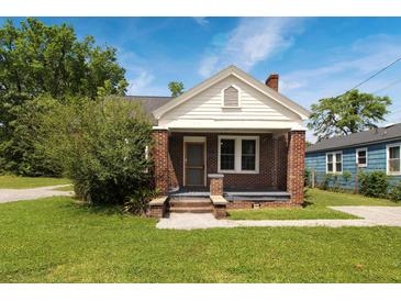 Charming brick home with a covered front porch and landscaped yard at 1808 Calvert St, North Charleston, SC 29405