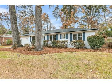 White brick ranch home with dark blue shutters, landscaping, and a spacious yard at 2462 Swallow Dr, Charleston, SC 29414