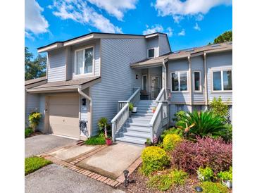 Inviting light gray home with landscaped gardens, and a spacious front porch at 668 Harbor Creek Place # 34, Charleston, SC 29412