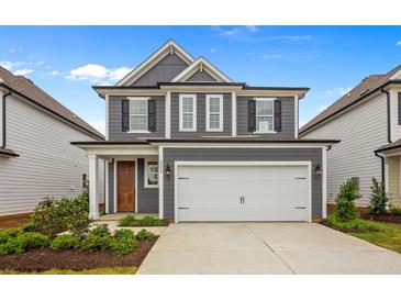 Two-story gray house with white garage door and landscaping at 318 Abercom Place Dr, Moncks Corner, SC 29461