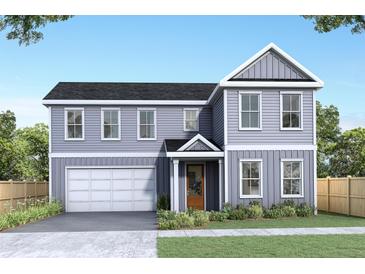 Two-story house with gray siding, attached garage, and landscaped yard at 5874 Hwy 165, Ravenel, SC 29470