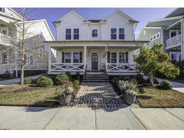 Charming two-story farmhouse with a wrap-around porch and brick walkway at 1518 Old Rivers Gate Rd, Mount Pleasant, SC 29466