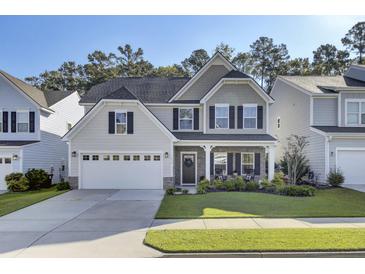 Two-story house with gray siding, white garage door, and a landscaped front yard at 434 Coopers Hawk Dr, Summerville, SC 29483