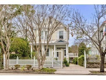 Charming yellow house with white picket fence and landscaped yard at 12 John St # Includes 8 & 10, Charleston, SC 29403