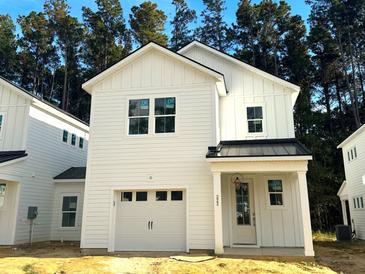 Two-story white farmhouse-style home with black metal roof and attached garage at 484 Queenview Ln, Charleston, SC 29414
