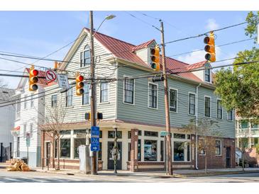 Charming two-story home with a light gray exterior and red roof at 132 Spring St, Charleston, SC 29403