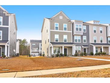Three-story townhome with neutral siding and landscaping at 352 Herty Park Dr, Moncks Corner, SC 29461